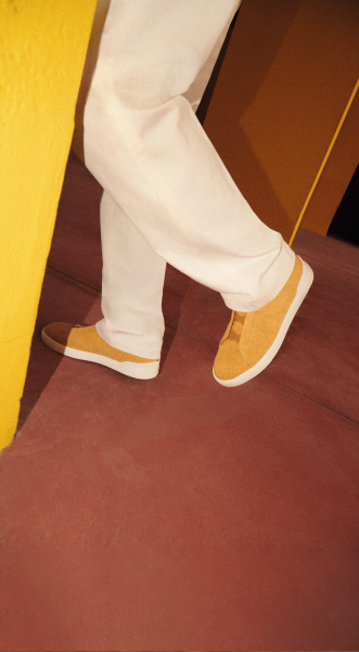 a person#s legs in white pants and yellow shoes description automatically generated with low confidence